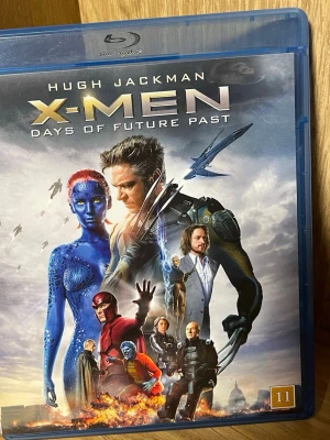 X-Men Days of Future Past Blu-ray - Blu-ray-film av X-Men: Days of Future Past med omslag i blå plastfodral. Filmen är på engelska och har åldersgräns 11 år. Omslaget visar flera av X-Men-karaktärerna och futuristiska element. Perfekt för dig som gillar superhjältefilmer och action.