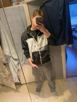 Svart och vit hoodie med dragkedja - Säljer en hoodie i svart, vitt och grått blockmönster. Hoodien har dragkedja framtill, stor huva och en magficka. Tillverkad i mjukt bomullsmaterial, perfekt för en chill och avslappnad stil. Storleken är XL men passar folk som är mindre än så.