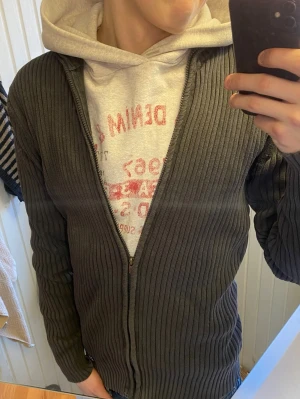 Brun ribbad ziptröja Jack & Jones - Säljer en brun ribbstickad ziptröja från Jack & Jones. Tröjan har dragkedja framtill, lång ärm och en klassisk rak passform. Perfekt att slänga över en hoodie eller t-shirt för en avslappnad look.