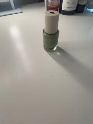 Grönt nagellack från IDUN - Säljer ett snyggt grönt nagellack från IDUN Minerals. Kommer i en stilren glasflaska med ljus kork och har en modern, fräsch nyans som passar dig som vill ha något unikt på naglarna. Perfekt för dig som gillar att experimentera med färg.
