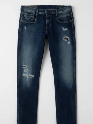 Mörkblå Replay Anbass med slitningar  - Säljer ett par mörkblå replay anbass jeans med slitningar och distressed detaljer på låren och knäna. Jeansen har klassisk femficksmodell och låg midja. Perfekta för en avslappnad och trendig look.