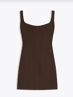 Brun kort klänning med breda axelband - En stilren brun kort klänning med breda axelband och figurnära passform. Klänningen har en fyrkantig ringning och markerade sömmar som ger en snygg siluett. Perfekt för dig som gillar minimalistisk design och vill ha något enkelt men trendigt. Aldrig använd. Passar xs-m då den är stretchig 