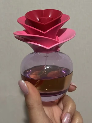 Justin Bieber parfym Someday 100ml - Justin Bieber ”Someday” 100ml från början ca 50ml kvar. Unik parfymflaska med ett iögonfallande lock format som en blomma i flera lager av rosa och rött. Flaskan är rund och genomskinlig med lila ton och innehåller bärnstensfärgad parfym. Perfekt som dekoration på sminkbordet eller i badrummet.