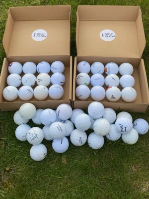 Florida mix 50-pack - Säljer ett stort parti vita golfbollar från Golf Glow och andra märken. Bollarna är klassiska med dimple-design och har tryckta loggor och text. Perfekt för golfträning eller spel. Levereras i två kartonger.