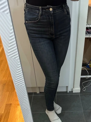 Mörkblå skinny jeans från Zara - Snygga mörkblå skinny jeans från Zara med hög midja och klassiska fem fickor. Jeansen har en smal passform och stängs med knapp och dragkedja. Perfekta för dig som gillar en tight och stilren look.