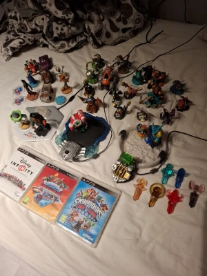 Skylanders och Disney Infinity PS3 spelpaket - Säljer ett stort paket med Skylanders och Disney Infinity till PS3. Inkluderar tre spel, massor av Skylanders-figurer, portaler och tillbehör i plast i olika färger och former. Perfekt för dig som gillar samlarfigurer och äventyrsspel med coola karaktärer.