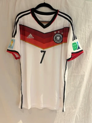 Tyskland 2014 Schweinsteiger #7 - Säljer Tyskland 2014 hemmatröja med Bastian Schweinsteiger på ryggen.  Riktig klassiker från året då Tyskland vann VM, där Schweinsteiger var en av lagets viktigaste spelare – speciellt i finalen där han krigade sönder hela matchen.  Spelade tillsammans med profiler som Philipp Lahm och Thomas Müller i ett av de mest kompletta landslagen någonsin.  Clean tröja med mycket historia – perfekt för både samlare och vardag.