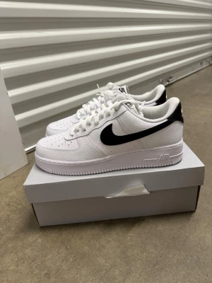 Nike Air Force 1 '07 Vit/Svart strl 45 - Helt nya oanvända Nike Air Force 1 '07 Vit/Svart strl 45. Skorna har inte blivit använda, inte heller testade. Helt nya.   Original kartong medföljer. Nypris hos Nike 1400 kr!