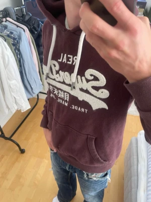 Brun vintage 2000s Superdry hoodie (Limited edition) - Säljer nu denna sjukt snygga Vintage 2000s SuperDry hoodie! Passar till allt och har en perfekt passform. Säljs ej längre i butik och är därav mycket eftertraktad😊 passar XS perfekt ! Skriv vid funderingar 🤝
