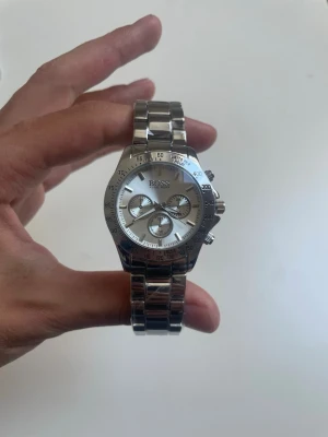 Vit HUGO BOSS Watch  - Klockan är 22 cm lång (17 cm om man inte räknar med själva klockan). Den är enkel att göra mindre och större och jag kan även göra det själv för en liten extra slant, se sista bilden (bara en överblick, inte samma klocka) Klockan är aldrig använd, helt ny! 🆕 Var inte rädd med att ge förslag och ge gärna bud! 🏆 