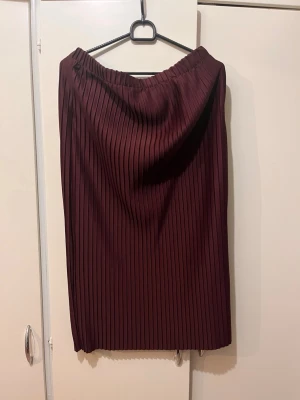 Vinröd burgundy midikjol Lindex strl M - Vinröd burgundy röd midi kjol från Lindex i strl M.  Jag är 160 cm lång för referens. Mycket fint skick. Material: polyester 