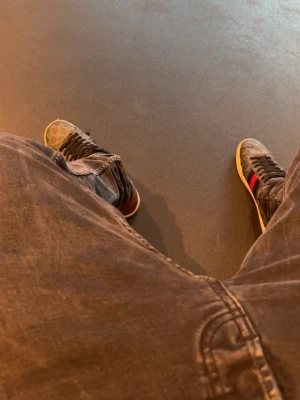 GG sneakers med monogram och röd-blå rand - Snygga sneakers från GG med klassiskt beige monogrammönster och ikoniska röd-blå ränder på sidorna. Skorna har svarta snören och vit sula. Perfekta för dig som vill sticka ut med en lyxig och trendig look.