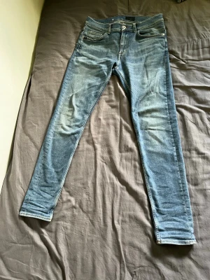 Slim fit jeans från Tiger of Sweden - Snygga slim fit jeans från Tiger of Sweden i ljusblå denim med klassisk femficksdesign. Jeansen har en något tvättad look och raka ben. Perfekta för dig som gillar stilrena och moderna jeans i bomull.
