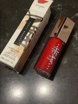 Fenty Beauty Gloss Bomb Heat Hot Cherry - Fenty Beauty Gloss Bomb Heat i färgen Hot Cherry 01. Ett läppglans med intensivt röd nyans och glansig finish. Kommer i en stilren fyrkantig förpackning med spegelblankt lock i roséguld. Innehåller 9 ml och ger en plumpande effekt.