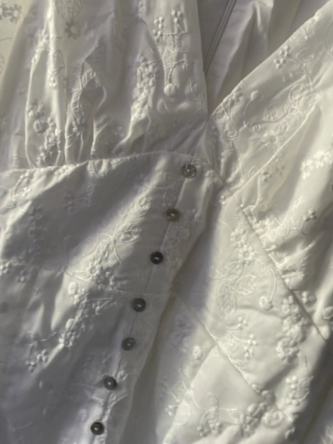Vit broderad kortklänning med knappar och lång puffärm. Stl M - 2