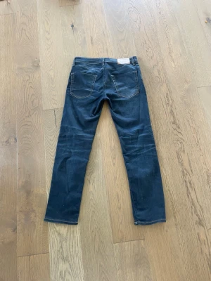 Mörkblå jeans med raka ben - Snygga jeans slim fit från Jack & Jones. Knappt använda då jag köpte dessa på en rea utan anledning och säljer av dem nu bara. Perfekta för en avslappnad och stilren look. Hör av dig vid frågor!!