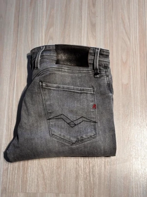 Grå replay jeans med slitningar - Tja! Säljer dessa grå replay jeans med slitningar. Finns flera små defekter som t.ex tunnt material vid skrevet. Storlek: W30 L32. Färg: Grå.