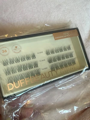 DUFFBEAUTY Premium Clusters fransar - DUFFBEAUTY Premium Clusters är handgjorda ögonfranskluster i svart färg. Förpackningen innehåller 36 kluster i längderna 10 mm, 12 mm och 14 mm. Perfekt för att skapa en fyllig och naturlig look. Kommer i en stilren ask.