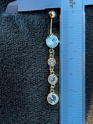 NY oanvänd Navelpiercing med hänge | Kirurgiskt stål | Vita stenar  - 💕30% Bundle-rabatt vid köp av minst 2 artiklar. ⭐️NY oanvänd piercing i kirurgiskt stål; rostfritt och säkert för läkta piercingar.                               📏MÅTT ⭕️Stavens längd: 10mm ⭕️Stavens tjocklek: 1,6mm ⭕️Smyckets totala längd: 60mm                                                                         🤍Färger: Guld och vit                                                            💌Skickas spårbart via Plick SafePay.