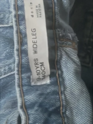 Blå wide leg jeans 140cm - Säljer ett par blå wide leg jeans från Denim i storlek 140 cm, passar ålder 9-10 år. Jeansen har klassisk femficksmodell och raka, vida ben. Perfekta för en avslappnad och trendig look.