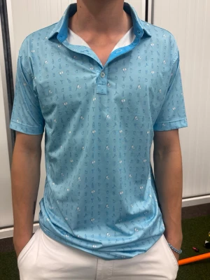 FootJoy golfpiké - Ljusblå skjorta med småmönstrat tryck i vitt och mörkblått. Nypris 1200kr. 