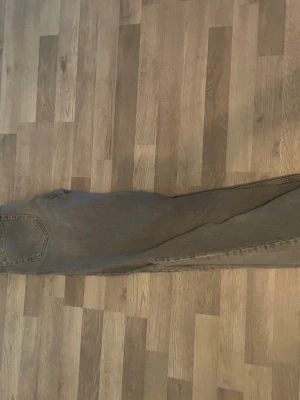 Grå raka flared jeans från Zara - Säljer ett par grå jeans med rak passform och klassisk femficksdesign. Jeansen har en lätt tvättad look som ger en vintage vibe och är tillverkade i denim. Perfekta för dig som gillar en avslappnad och stilren stil.