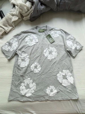 Grått denim tear set med vita blommor - Helt nytt. Storlek L i shorts och L eller XL i tröjan. Inga teckan på användning eftersom den är helt ny. Skriv vid funderingar. Pris kan diskuteras vid snabb affär.