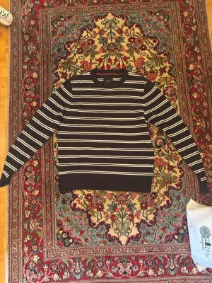 Svartvit randig stickad tröja - Snygg stickad tröja från S.C.W i mörkblå med vita horisontella ränder. Tröjan har rund halsringning och ribbade muddar vid ärmslut och nederkant. Perfekt för en stilren och avslappnad look.