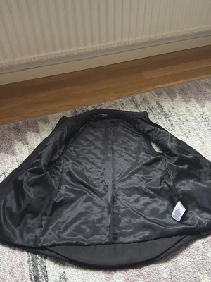 Svart quiltad dunväst med dragkedja - Snygg svart dunväst med quiltat mönster och hög krage. Västen har en silvrig dragkedja framtill och två fickor på sidorna. Lätt figursydd passform och längre bakstycke för extra stilpoäng. Perfekt för lager på lager under kyliga dagar.