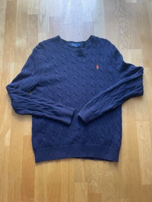Ralph Lauren M Man kabelstickad tröja  - Hej, den är i jättebra skick använd ett fåtal gånger. Storlek m och sitter bra. Skriv vid frågor