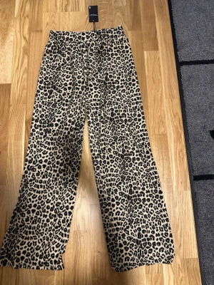 Leopardmönstrade byxor stl S - orda i ett mjukt, skönt material som passar perfekt för chill dagar. Djurmönstret ger en trendig och cool vibe till din outfit.