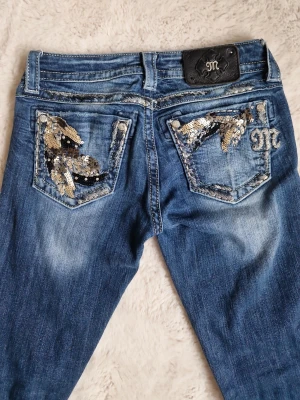 Lågmidjade bootcut miss me jeans - Ascoola utsvängda miss me jeans!! Inga större defekter förutom att en av fyra saker på märket är lös och att baksidan av ett av benet visar tecken på användning (se bilder) 💞 Storlek 26 men gissar att det är typ xs