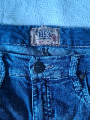 Midrise blå jeans från 1953 Molly - Blåa jeans men en hint av grå från Molly 1953 som är perfekt för dig som vill ha lite äldre jeans men inte så använda. Jeansen är i storlek 40 och fortfarande lite låga I midjan som vill att jeansen inte ska sitta åt så mycket men fortfarandevara lite låga. . 
