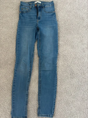 Blå Molly skinny jeans från Gina Tricot - Säljer ett par blå Molly skinny jeans från Gina Tricot. Jeansen har hög midja, klassisk femficksmodell och stretchigt material för en bekväm passform. 
