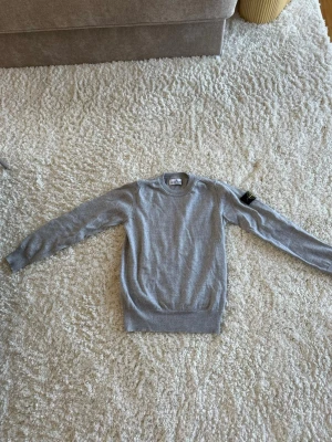 Grå stickad tröja från Stone Island - Säljer en väldigt fin stone Island stickad tröja. Storleken är lite stor. Den är 142cm men passar lite större. 🎨 ◻️ Skick: 10/10  Pris 499kr