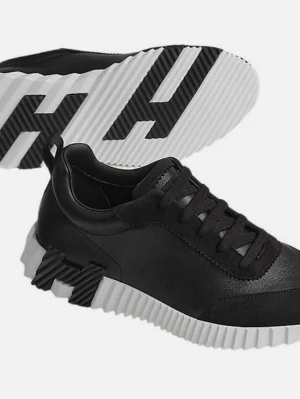 H skor - Snygga svarta sneakers med chunky, räfflad vit sula och vita skosnören. Skorna har en modern design med blandning av textil och syntetmaterial. Perfekta för dig som vill sticka ut med en unik och trendig look.