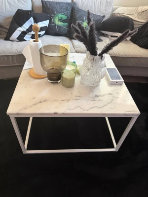 Vitt soffbord med marmorskiva - Hej Säljer SuperFint 💯 Äkta  Marmorbord Stilrent soffbord med vit marmorinspirerad skiva och vit metallram. Bordet är fyrkantigt och har en modern, minimalistisk design som passar perfekt till vardagsrummet. Perfekt för att ställa dekorationer, ljus eller fjärrkontroller på. Mått 30X 19 Cm Vikt 80kg Bordskivan Inga skador Repor superfint Fnns Bara Vid kanten men ingeting som syns eller man Lägger Märke Till som Nytt! Har du Frågor Funderingar Fråga Gärna Tack!😊