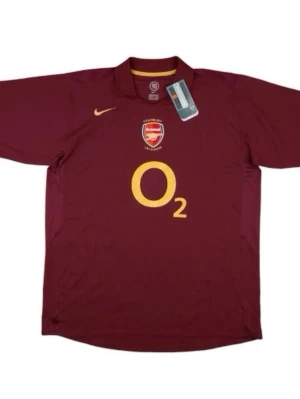 Arsenal retro matchtröja Henry 14 - Säljer en vinröd Arsenal matchtröja från Nike med klubbmärke och O2-logga framtill. På ryggen står det Henry 14 i gult och texten Highbury 1913-2006. Klassisk pikékrage och korta ärmar. Perfekt för fotbollsfans!