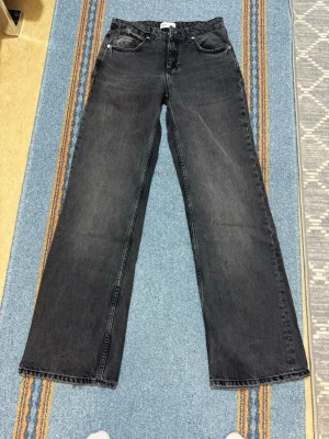Svarta raka jeans från Zara - Snygga svarta jeans från Zara med rak passform och klassisk femficksdesign. Jeansen har en lätt tvättad look och är tillverkade i denim. Perfekta för en avslappnad och trendig stil.