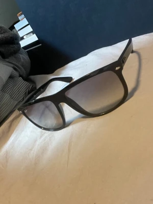 rayband boyfriend - Snygga svarta solglasögon med bred båge och stora, fyrkantiga glas. Glasen är tonade och ger en cool look. Passar perfekt till sommaren och ger en trendig vibe till din outfit.