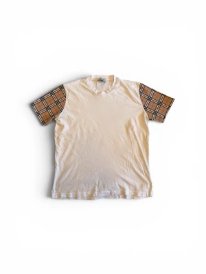 Burberry T-shirt - Burberry t-shirt med kortärmade ärmar i klassiskt brunt rutigt mönster. Perfekt för sommaren med fin klassisk Burberry design. Tveka inte att ställa frågor, priset går att diskutera vid snabb affär!