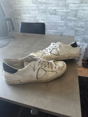 Vita sneakers med svart häl - Philippe model prsx Low White Köpt från Merchsweden 3200kr. Har kvitto och allt som ingick med skorna kvar. Säljer dom då jag inte använder dom längre. Inga defekter på dom.  Innan jag skickar dom tvättar jag dom självklart och gör dom så fina som möjligt!  Skriv för frågor eller fler bilder!