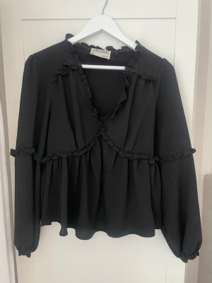 Svart blus med volangdetaljer - Svart blus från vero moda. Kostar 500 nypris och sitter lite löst i passformen. 