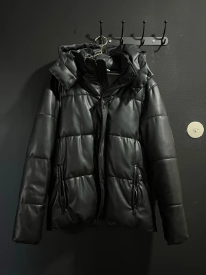 Zara Pufferjacka - Tjena, Säljer en svart pufferjacka från Zara. Jackan har två sidofickor med dragkedja. Materialet ser ut som glansig syntet eller fejkläder. Det är storlek L men sitter som M!