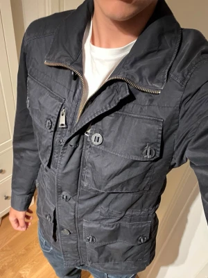 Mörkblå J.Lindeberg fieldjacka - Fet mörkblå fieldjacka från J.Lindeberg. Använd men sparsamt och finns inga större tecken på slitage. Hör av dig vid fler frågor!