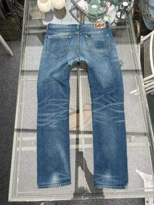 Lee jeans W34 L32 – blå denim (mycket bra skick) - Säljer ett par snygga Lee jeans i blå denim med riktigt nice fade 🔥 Perfekta för vardag och enkla att styla.  • Märke: Lee • Modell: Jegger • Storlek: W34 L32 • Färg: Blå • Skick: Mycket bra – inga hål eller defekter • Passform: Slim/regular fit  Sitter bra och har en naturligt sliten look som ger extra stil 👌  Pris: 400 kr (kan diskuteras vid snabb affär) 