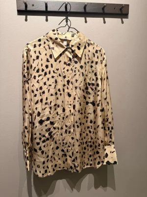 Beige leopardmönstrad skjorta - Så skön och snygg skjorta i leopardmönster. Skjortan är använd max 2 gånger och är i 100% silke. 