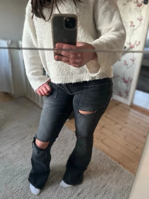 Svarta slitna bootcut jeans - Säljer ett par mörk gråa bootcut jeans 