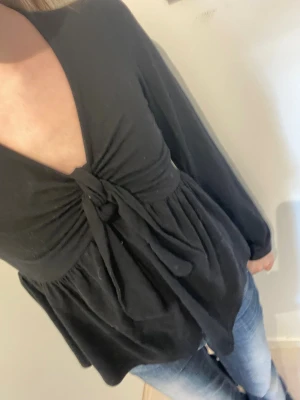 Svart långärmad blus med knyt - Trendig svart blus med djup v-ringning och knytband framtill.  Köpt för 300kr, från kids brand store ❤️ skriv om du har frågor 