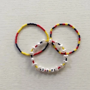 Djurgården Armband  Set 💙❤️ Nytt armband görs vid varje köp! - Tre handgjorda armband med små pärlor i blått, gult och rött. Ett av armbanden har vita pärlor med bokstäverna 'DIF'. Perfekt accessoar för dig som gillar färg och vill sticka ut.